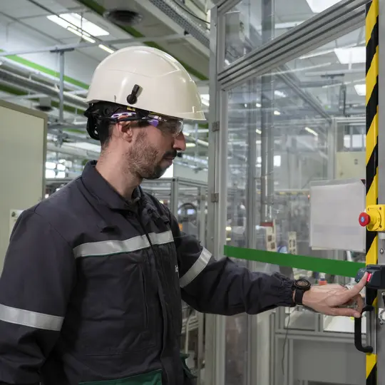 Man in factory with safety goggles and helmet